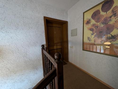 a stairway with a painting of flowers on the wall at Ferienwohnung am Almberg in Philippsreut