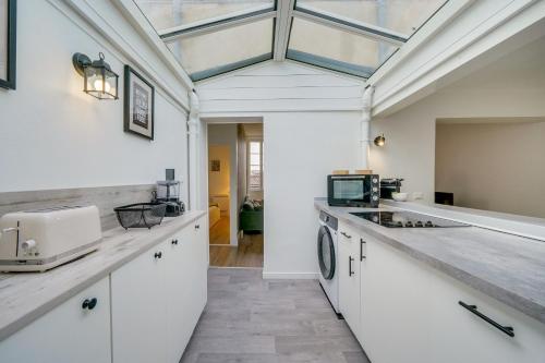 d'une cuisine avec des placards blancs et un plafond en verre. dans l'établissement Le Sauvage - Au coeur du quartier St Pierre, à Bordeaux