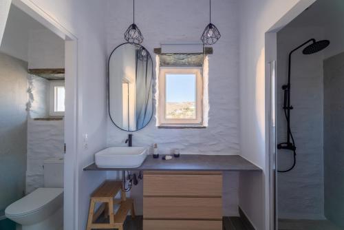 a bathroom with a sink and a mirror at Petra Vista Retreats in Otzias