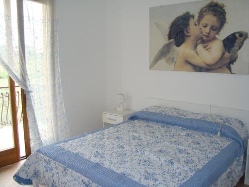 バルドリーノにあるCasa Sole Appartement con terrazzoのベッドルーム1室(壁に絵画が描かれたベッド1台付)