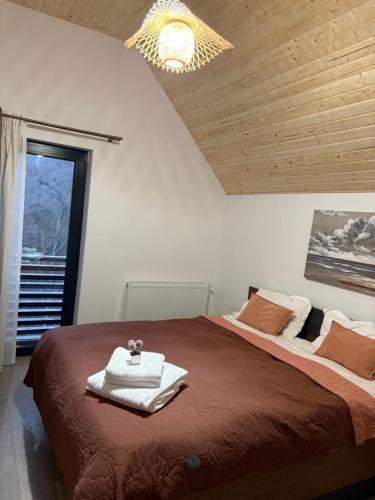 a bedroom with a large bed and a chandelier at Vila Epic&Slanic Moldova in Slănic-Moldova