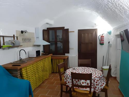 a kitchen with a table and a small table and a table and a kitchen with at El Melocotonero in Benalúa de Guadix