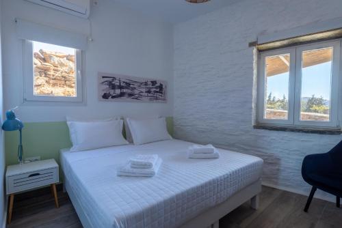 a bedroom with a white bed with two towels on it at Petra Vista Retreats in Otzias