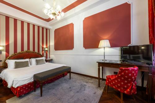 a bedroom with a bed and a desk and a television at Hotel Casa Verardo Residenza d'Epoca in Venice
