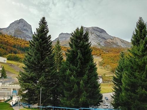 un groupe de pins avec des montagnes en arrière-plan dans l'établissement A la montagne, à Eaux-Bonnes