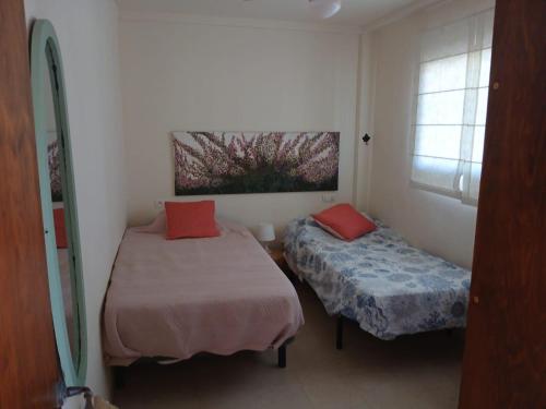 a small room with two beds and a window at La Traiña in Adra