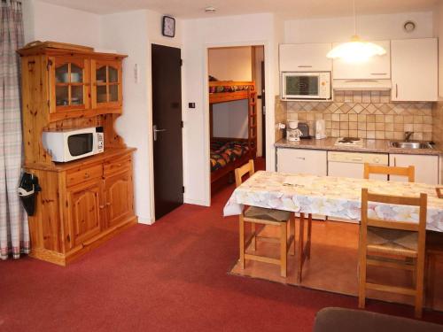 une petite cuisine avec une table et un micro-ondes dans l'établissement Joli studio 4 pers. au centre de la station, accès pistes - FR-1-322-175, aux Orres