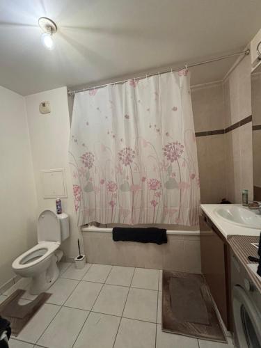une salle de bain avec toilettes et rideau de douche dans l'établissement T2 proches Paris, au Blanc-Mesnil