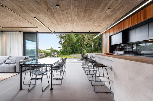 a dining room with a long table and chairs at Casa Cave by Achei in Canela
