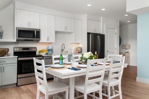 a kitchen with a white table and white chairs at Island House Newport in Newport