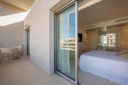 une chambre avec un lit et une grande fenêtre en verre dans l'établissement 152 Boulevard Eugène Gazagnaire, à Cannes