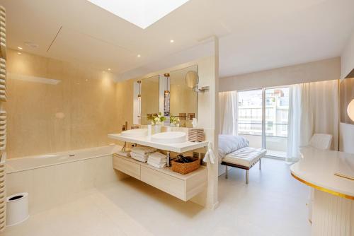 une salle de bain avec un lavabo, un miroir et une baignoire dans l'établissement 152 Boulevard Eugène Gazagnaire, à Cannes