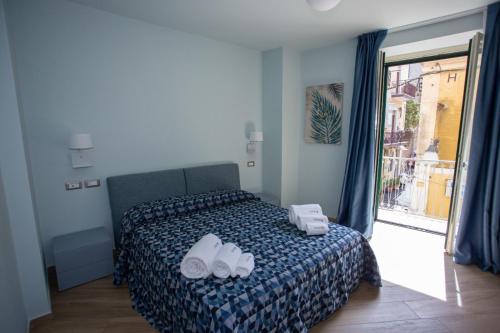 a bedroom with a bed with shoes on it at Odissea Residence e Rooms in Santa Maria di Castellabate