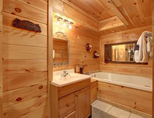 Un baño con lavabo y bañera. en Game room, hot tub, flat easy drive to 3BR cabin!, en Sevierville