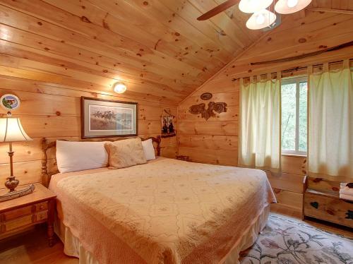 Un dormitorio con una cama en una cabaña de troncos en Game room, hot tub, flat easy drive to 3BR cabin!, en Sevierville