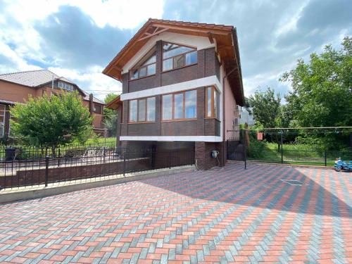 a house with a brick driveway in front of a fence at Дом для отпуска in Codru