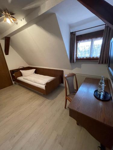 a room with a bed and a table and a window at Landhotel Sickinger Hof in Walldorf