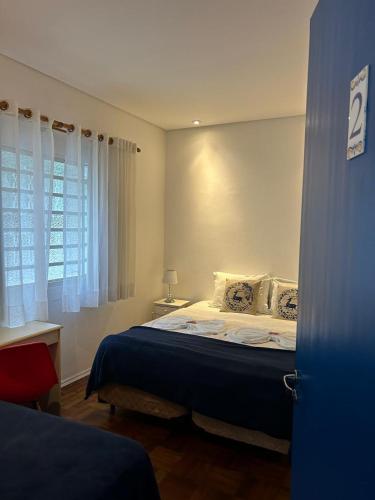 a bedroom with a bed and a desk and a window at Pousada e Hostel São Paulo Comfort - Bairro Pinheiros, próximo Hospital das Clínicas e Incor, Oscar Freire, Av Paulista, Allianz, Vila Madalena e fácil acesso ao Ibirapuera e Morumbi in Sao Paulo