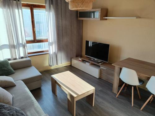 salon z kanapą, stołem i telewizorem w obiekcie Apartamento Shenzhen en Astorga Camino de Santiago Cochera bicis w mieście Astorga