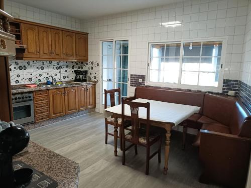 kuchnia z drewnianymi szafkami, stołem i krzesłami w obiekcie Apartamento Shenzhen en Astorga Camino de Santiago Cochera bicis w mieście Astorga