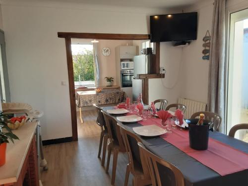 - une longue table avec des serviettes rouges et des verres dans l'établissement Maison du pêcheur, forêt et océan, à Notre-Dame-de-Monts