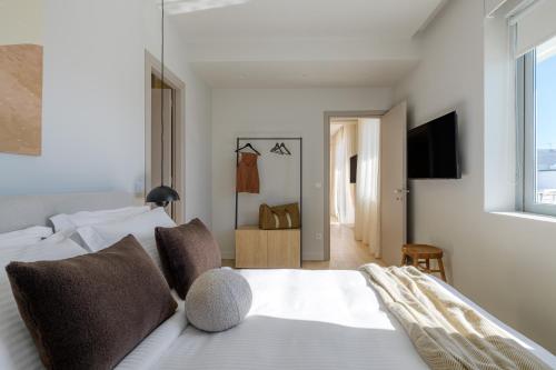a bedroom with a white bed and a television at Acropolis Penthouse Plunge Pool in Athens