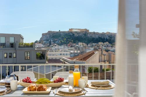 a table with food and a view of a city at Acropolis Penthouse Plunge Pool in Athens