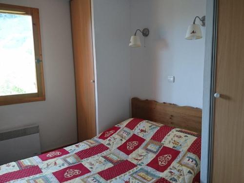 une chambre avec un lit avec une couette dessus dans l'établissement Appartement 2 pièces avec balcon, piscine, sauna et parking, à 50m des pistes - FR-1-263-399, à Valloire