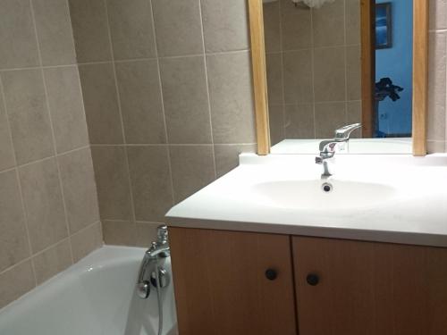 une salle de bain avec un lavabo et une baignoire dans l'établissement Appartement 2 pièces avec balcon, piscine, sauna et parking, à 50m des pistes - FR-1-263-399, à Valloire
