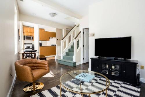 a living room with a tv and a glass table at Delightful North End Apt 2BR 2BA Laundry in Boston