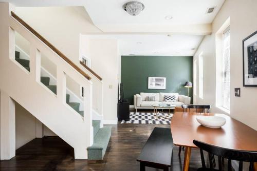 a living room with a staircase and a table and chairs at Delightful North End Apt 2BR 2BA Laundry in Boston