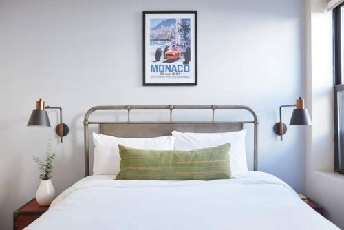 a bedroom with a bed and a poster on the wall at Delightful North End Apt 2BR 2BA Laundry in Boston