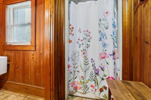 a shower curtain with flowers on it in a bathroom at KD2043- The Gray House in Kill Devil Hills