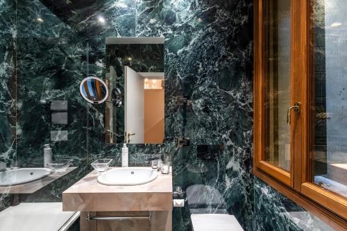 a black marble bathroom with a sink and a mirror at Hotel Casa Verardo Residenza d'Epoca in Venice