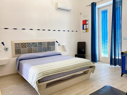 Un dormitorio con una cama y dos ventanas. en Casa Mondrian - Comfort e Design con Piscina Privata, en Tiggiano