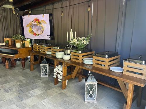 a long wooden table with plates and plants on it at Gec in Zaprešić