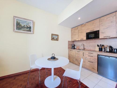 une cuisine avec une table blanche et des chaises dans l'établissement Nestor&Jeeves - KRIBI - Central, à Nice