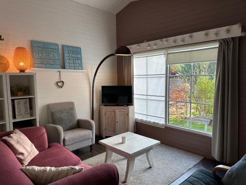 ズテンダールにあるChalet Happinessのソファ、テレビ、テーブルのあるリビングルーム