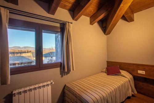 a small bedroom with a bed and a window at Mas d'Aravó in Bolvir