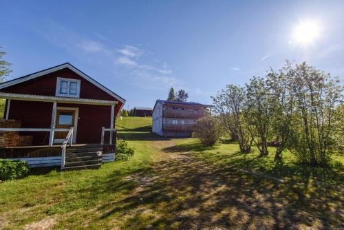 a small house in a field with a barn at Knutes pensionat in Svansele