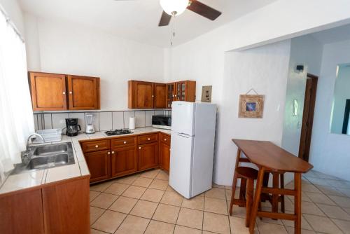 a kitchen with a white refrigerator and a table at Condiminium Villas Mymosa in Manuel Antonio