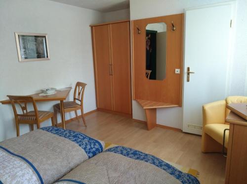 1 dormitorio con cama, mesa y armario en Landhaus Fohlenhof, en Mehrstetten