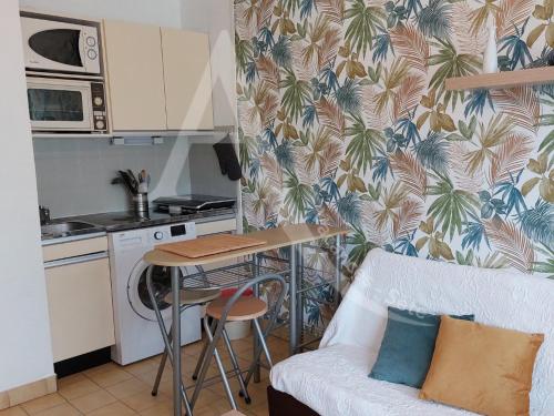 un salon avec un canapé et une cuisine dans l'établissement T2 quartier Quilles renove avec gout WIFI 4 personnes, à Sète