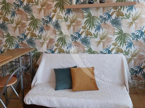 - un canapé blanc avec un oreiller dans l'établissement T2 quartier Quilles renove avec gout WIFI 4 personnes, à Sète