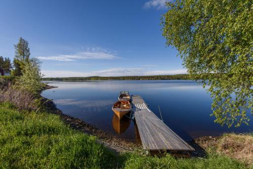 a boat is docked at a dock on a lake at Knutes pensionat in Svansele