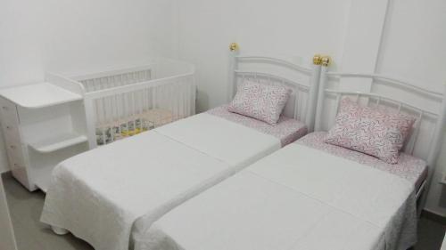 1 dormitorio con 2 camas y almohadas rosas en Casa Maré & Museu - Porta Nº 18, en Mindelo