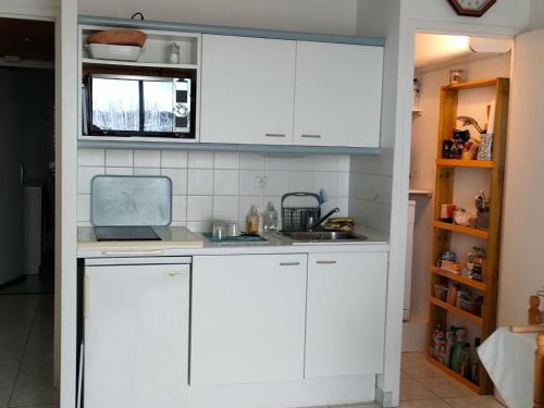 une cuisine avec des armoires blanches et un évier dans l'établissement Ref 137 Appartement pour 2 vue port du Crouesty ARZON, à Arzon