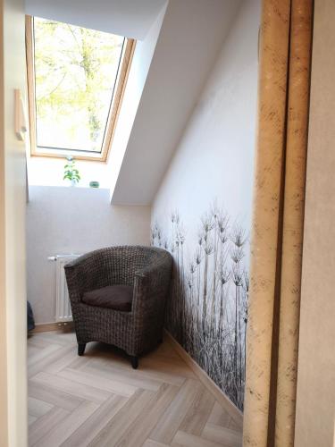 a chair in a room with a painting on the wall at Apartament Górski Widok in Szklarska Poręba