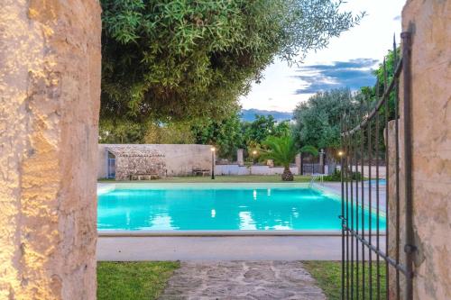 a swimming pool in a yard with a fence at Masseria Testaferrata in Siracusa