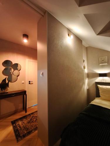 a bedroom with a bed and a hallway with a door at Apartament Górski Widok in Szklarska Poręba